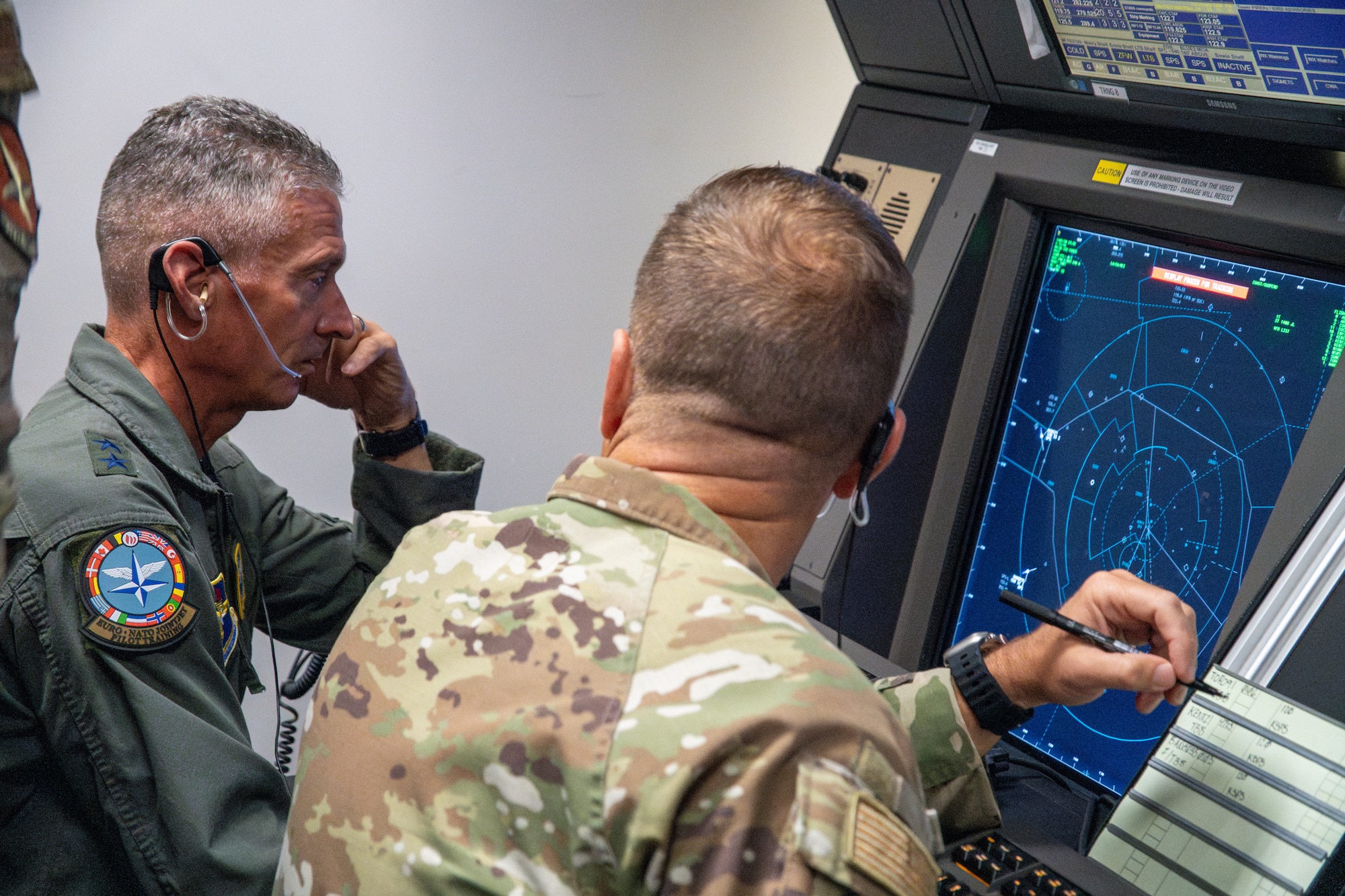 U.S. Air Force Maj. Gen. Gregory Kreuder, 19th Air Force commander, and Chief Master Sgt. Keith Scott, 19th AF command chief operate a Radar Approach Control simulator