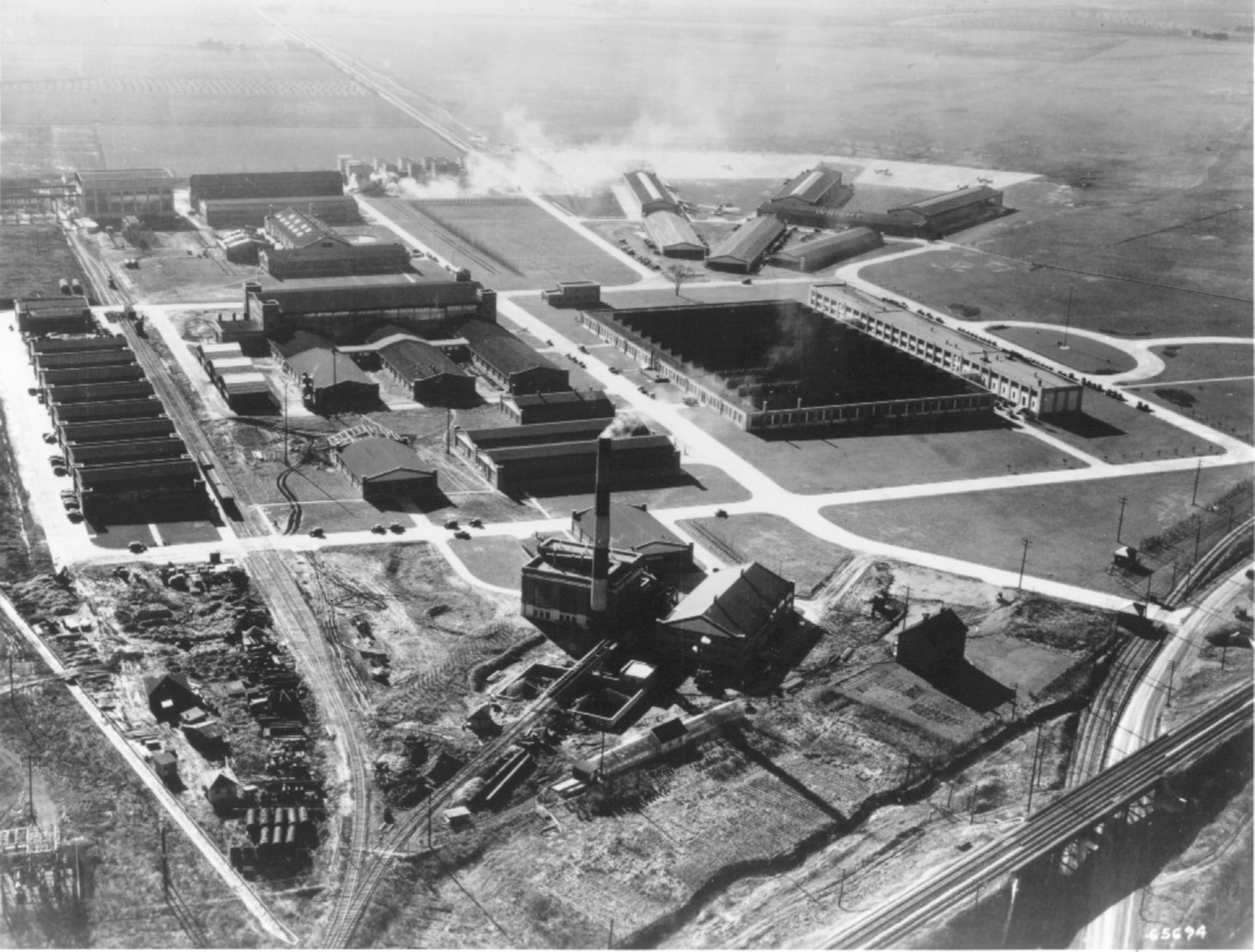 Aerial View of land, buildings, railroad, and roadways.