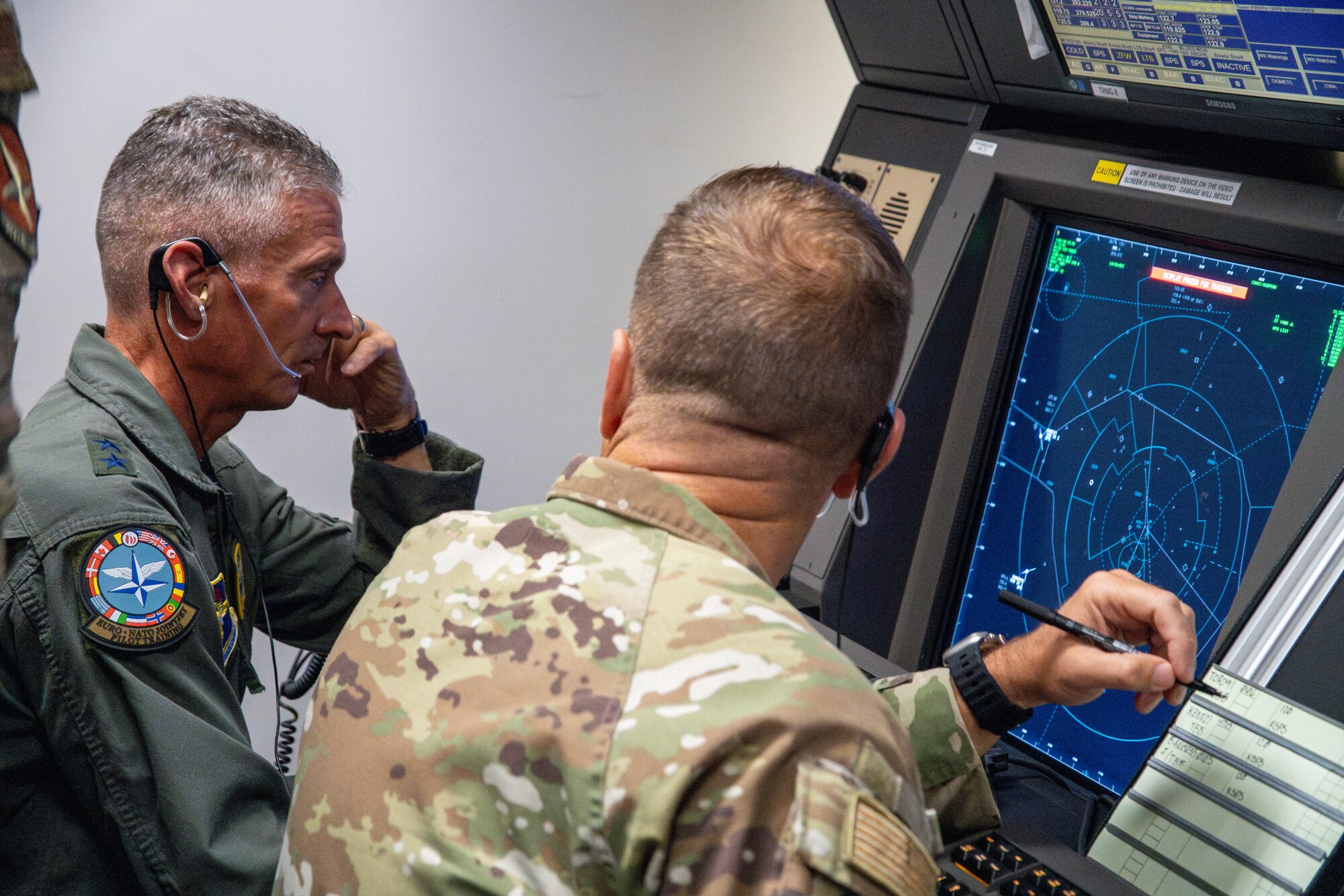 U.S. Air Force Maj. Gen. Gregory Kreuder, 19th Air Force commander, and Chief Master Sgt. Keith Scott, 19th AF command chief operate a Radar Approach Control simulator