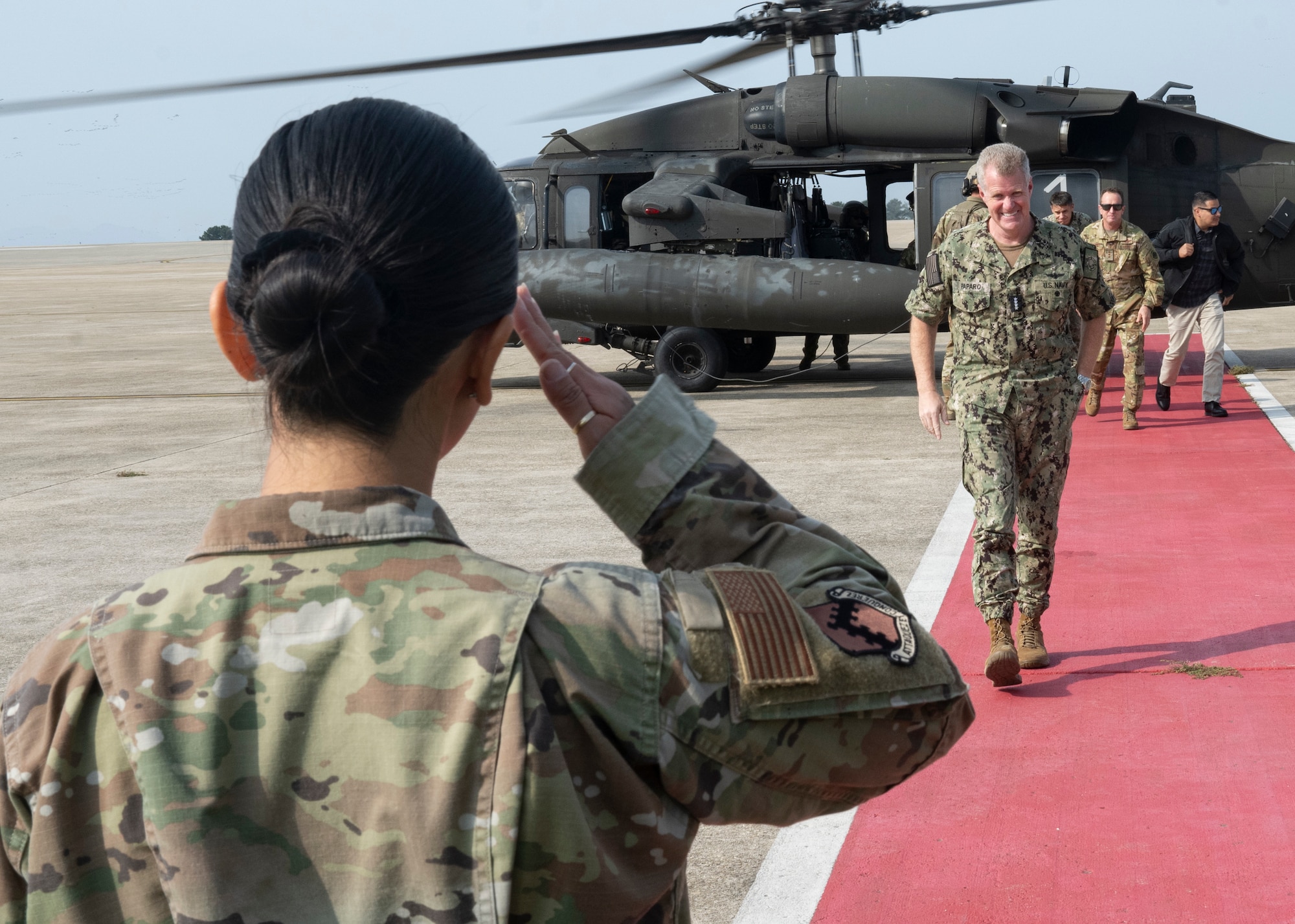 U.S. Air Force 1st Lt. Leia Lau, 8th Fighter Wing protocol officer, salutes U.S. Navy Adm. Samuel J. Paparo, U.S. Indo-Pacific Command commander, as he arrives at Kunsan Air Base.