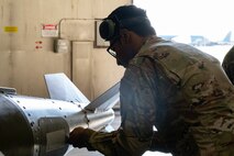 Senior Airman Christo Jose, 23rd Bomber Generation Squadron load team member, opens an access hatch on an inert GBU-31 in preparation to load it onto a B-52H Stratofortress at Minot Air Force Base, Oct. 4, 2024. Christo served on a team competing on how efficiently and safely they can load the munition onto the aircraft. (U.S. Air Force photo by Airman 1st Class Wesley Davies