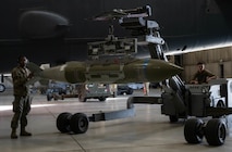 Senior Airman Ronnely Hights (left) and Airman 1st Class Daniel Hanks (right), team members in the 69th Bomber Generation Squadron, lift an inert GBU-31 in preparation for loading at Minot Air Force Base, Oct. 4, 2024. The crew is required to have precise control over the inert GBU-31 at all times in order to safely and efficiently load it onto the aircraft. (U.S. Air Force photo by Airman 1st Class Wesley Davies)