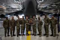 Airmen assigned to the 23rd Bomber Generation Squadron pose for a group photo with 5th Bomb Wing leadership after winning the third-quarter load competition at Minot Air Force Base, Oct. 4, 2024. For the competition, crews were given a written and practical test as well as a dress and appearance inspection. (U.S. Air Force photo by Airman 1st Class Wesley Davies)