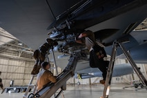 Airmen assigned to the 69th Bomber Generation Squadron load team attach an inert GBU-31 to the underside of a B-52H Stratofortress wing during a load competition at Minot Air Force Base, Oct. 4, 2024. These competitions showcase the skills and teamwork of these crews, and also play a significant role in enhancing mission readiness and strengthening global strike capabilities. (U.S. Air Force photo by Airman 1st Class Wesley Davies)