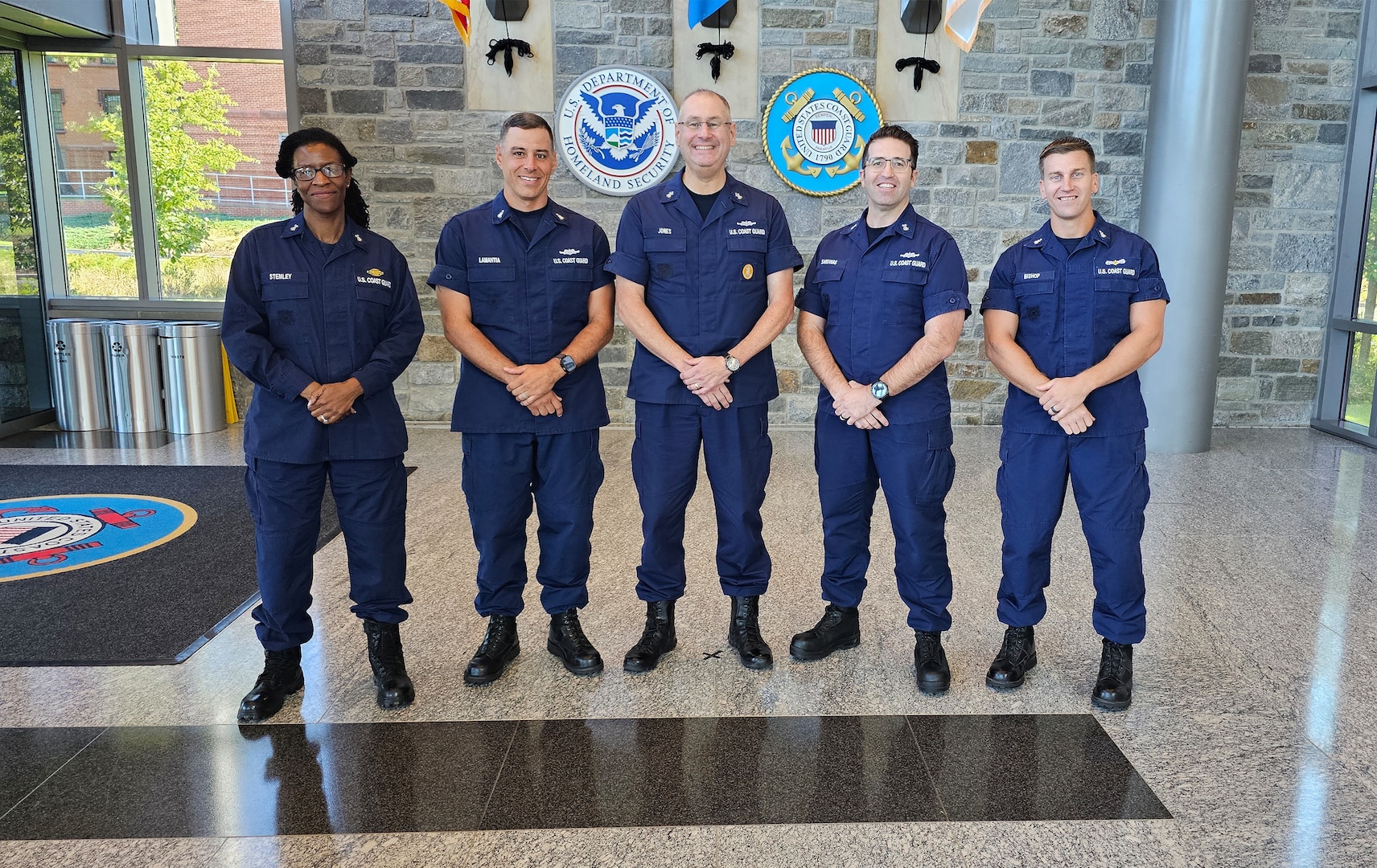 Pictured from left to right is ITCM Nia Stemley, MKCS Sal LaMantia, MCPOCG Heath Jones, EMCM Jason Sardinas, and BMCS Brad Bishop, all posing for a photo at the Coast Guard Headquarters.