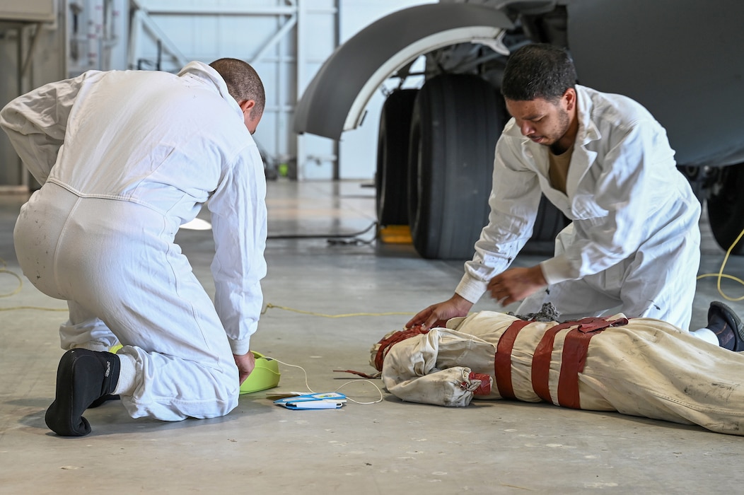 Staff Sgt. Ryan Collier, left, and Senior Airman David Asterino, 445th Maintenance Squadron fuels systems specialists, remove a simulated unresponsive person from the aircraft underfloor maintenance tunnel of a C-17 Globemaster III and prepare to perform CPR during a training exercise at Wright-Patterson Air Force Base, Ohio, Sept. 15, 2024.