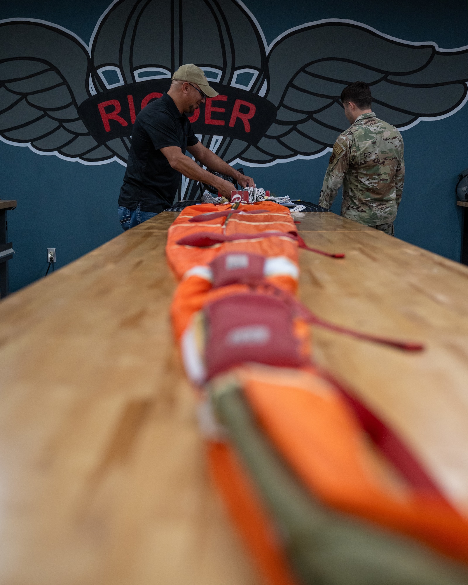 Roger Gloria, 47th Operations Support Squadron (OSS) aircrew flight equipment (AFE) parachute rigger, left, and Senior Airman Christian Quiroz, 47th OSS AFE technician, right, repack and inspect the parachute rigging at Laughlin Air Force Base, Texas, Oct. 3, 2024. Packing parachute rigging is a precise process, with every line needing to be pulled and set in a particular position to ensure the parachute opens perfectly in its moment of need. (U.S. Air Force photo by Staff Sgt. Nicholas Larsen)