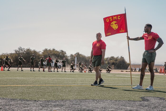 U.S. Marine Corps Capt. Philip Gianopoulos, left, a series commander for Charlie Company, 1st Recruit Training Battalion, and Staff Sgt. Deandre Lee, a chief drill instructor with Charlie Company, 1st Recruit Training Battalion, observes recruits during a physical training session at Marine Corps Recruit Depot San Diego, California, Oct. 1, 2024. The recruits conducted a series of stations such as side shuffles, ammunition can lifts, planks, single-leg Romanian deadlifts, bicycle crunches, and 440-yard sprints during their physical training event strengthening themselves physically and mentally. (U.S. Marine Corps photo by Cpl. Sarah M. Grawcock)