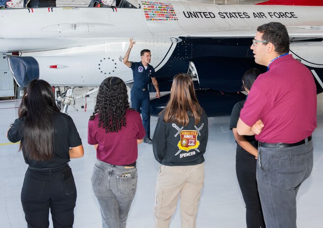 Students from Eldorado High School are shown an F-16 Fighting Falcon aircraft during a tour at Nellis Air Force Base