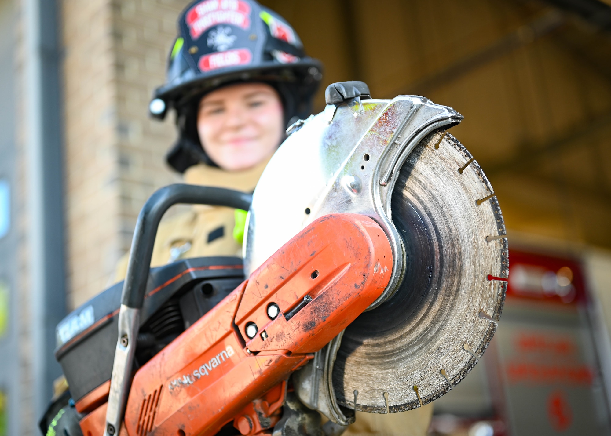 An firefighter wields a saw.