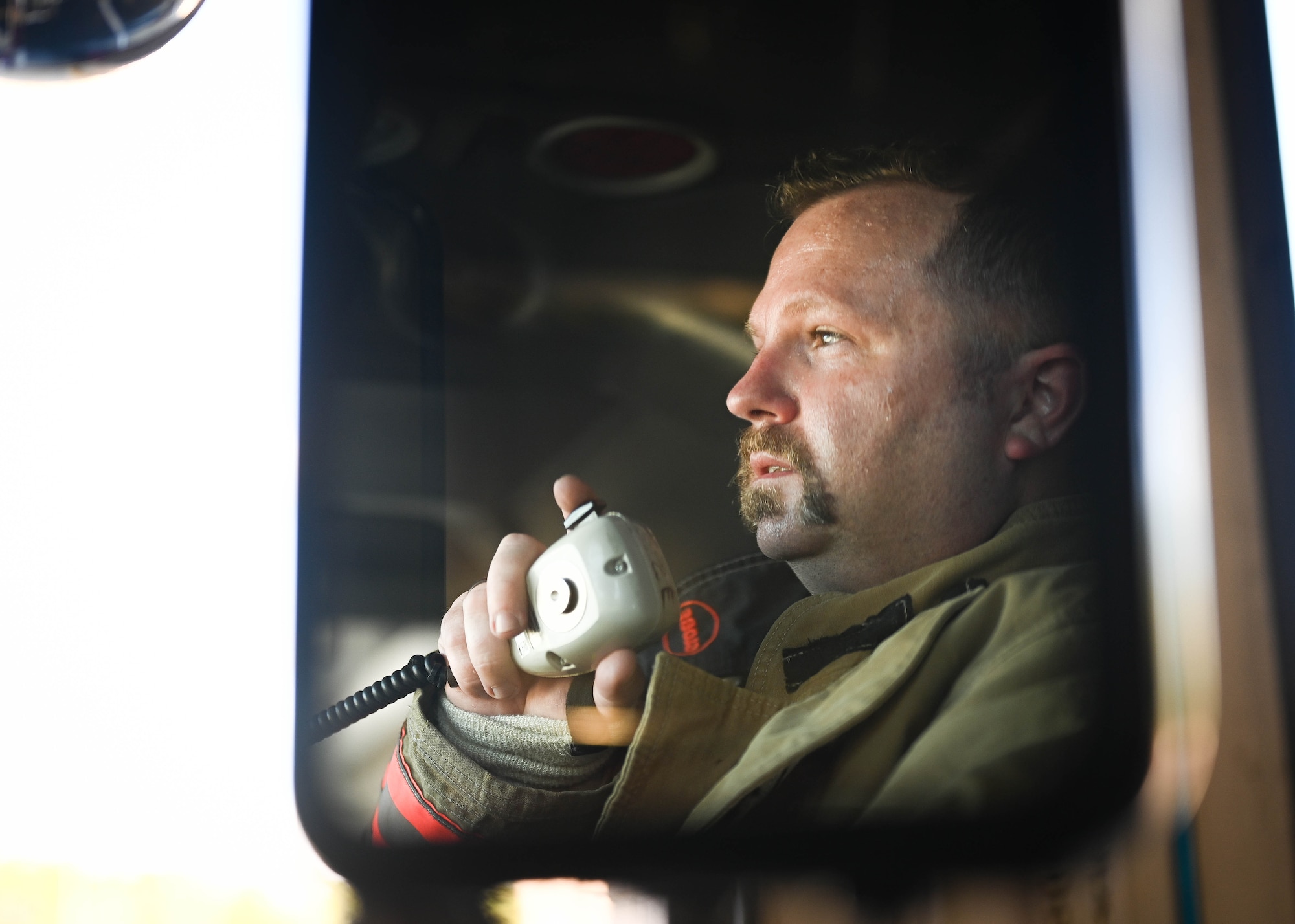 A fire captain speaks into a radio.