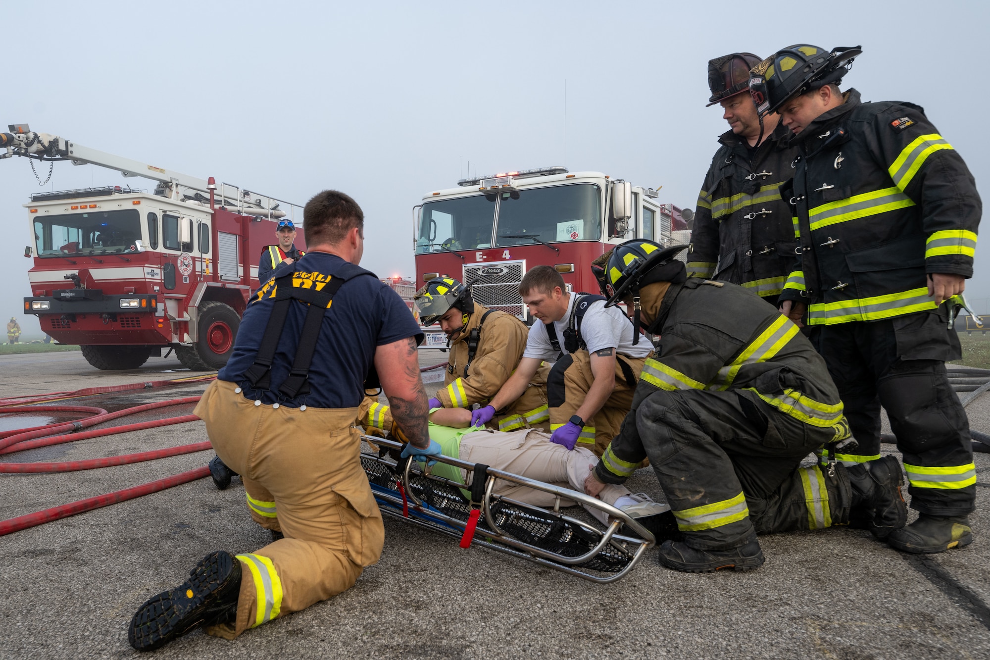 Airmen assigned to the 130th Fire and Emergency Services and members of the Charleston Fire Department prepare to move a simulated patient to a nearby staging area during the major accident response exercise (MARE) on October 05, 2024 at Charleston, W.Va. Team Charlie West trains alongside its strategic partners at West Virginia International Yeager Airport during the MARE, the Federal Aviation Administration requires airports every three years to perform this training to operate commercial aircraft. (U.S Air National Guard photo by Staff Sgt. Takara Williams).