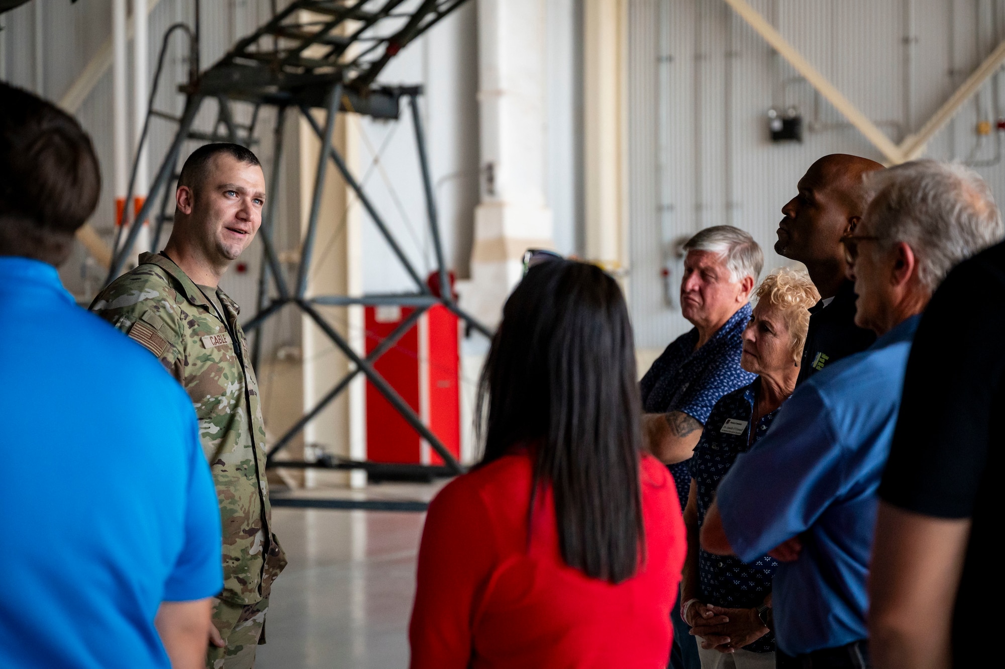 Honorary commanders pose for a group photo during a tour in front of a C-130J
