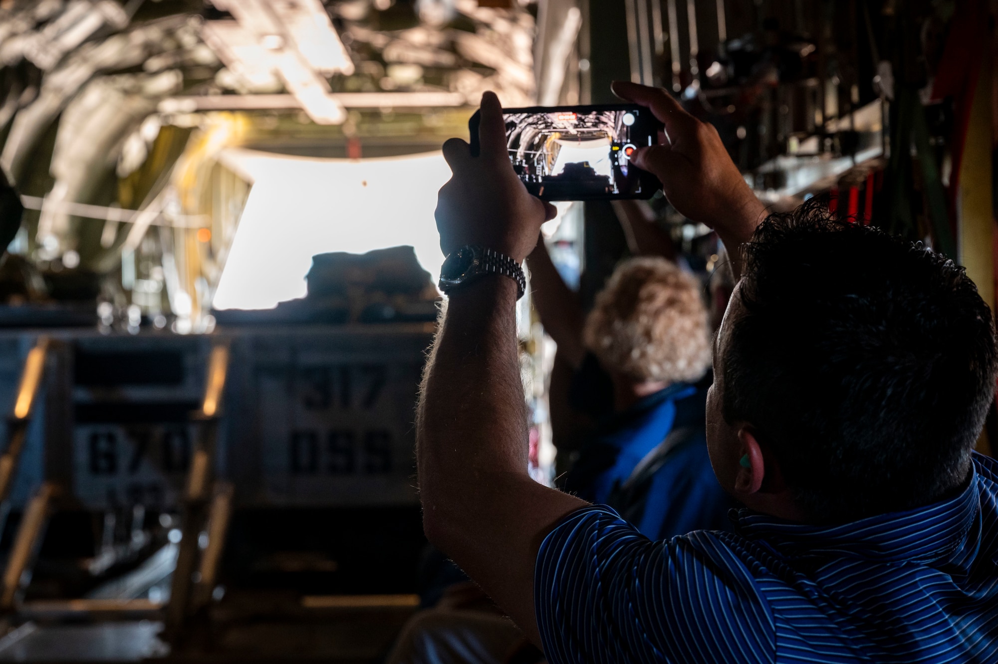 Honorary commanders pose for a group photo during a tour in front of a C-130J