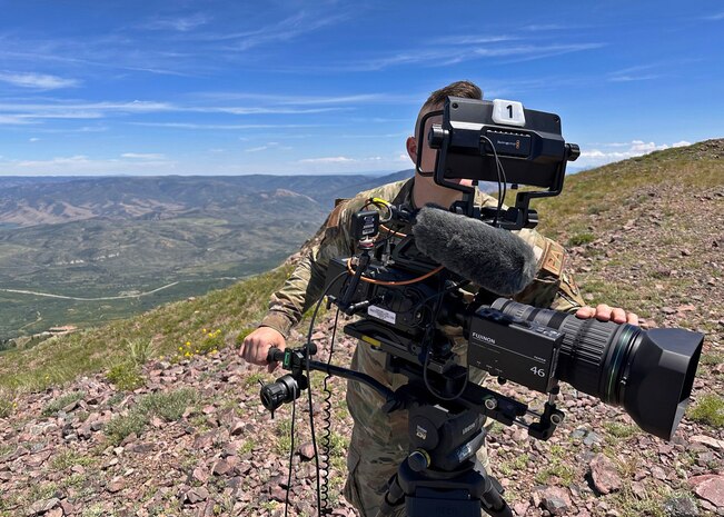 A member of the 2d Audiovisual Squadron is shown looking into the camera atop Snowbasin Resort's Strawberry Gondola.