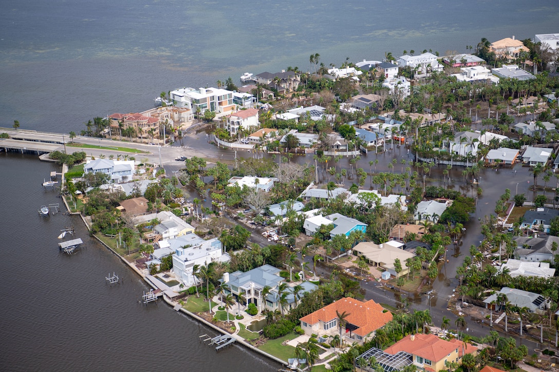 An aerial view of a waterfront neighborhood with visible flooding.