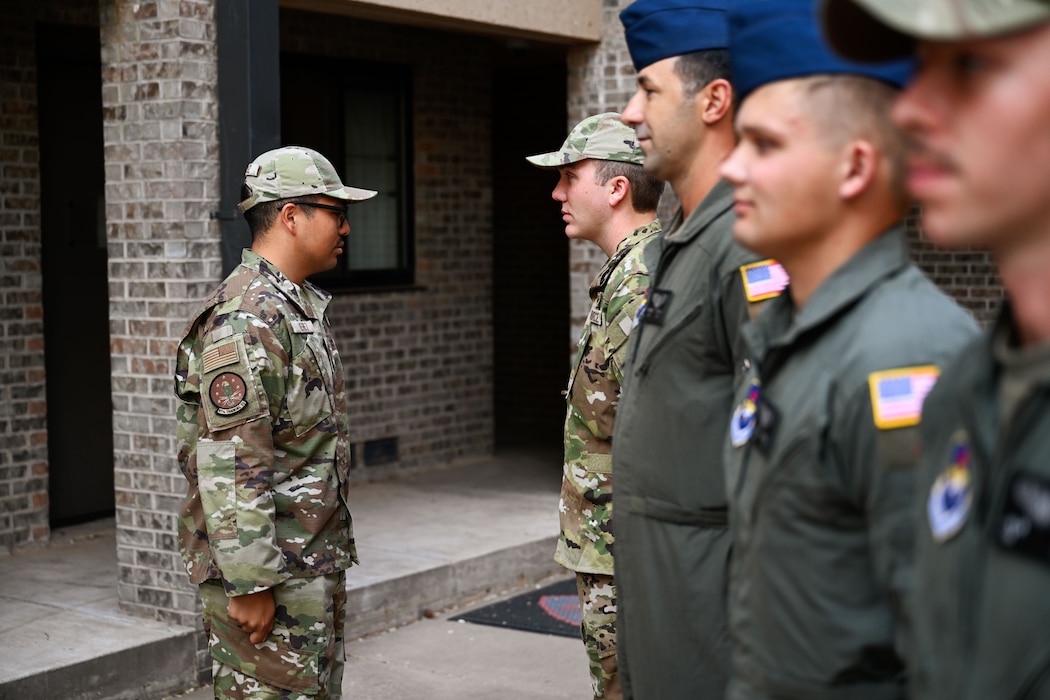 U.S. Air Force Tech. Sgt. Mario Perez, 97th Training Squadron (TRS) military training leader (MTL), conducts an open ranks inspection at Altus Air Force Base, Oklahoma, Oct. 7, 2024. During open ranks, MTLs assess and mentor Airmen, ensuring they understand uniform standards while fostering a culture of accountability. (U.S. Air Force photo by Airman 1st Class Jonah Bliss)