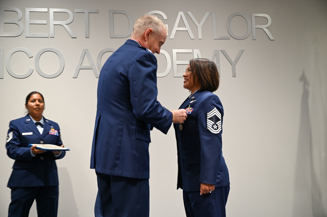 Retired Col. Michael D. Nelson, a former 433rd Medical Squadron commander, pins the Meritorious Service Medal onto Chief Master Sgt. Lisa Lopez, 433rd Aeromedical Evacuation Squadron senior enlisted leader, during a retirement ceremony in Joint Base San Antonio-Lackland, Texas, Oct. 5, 2024.