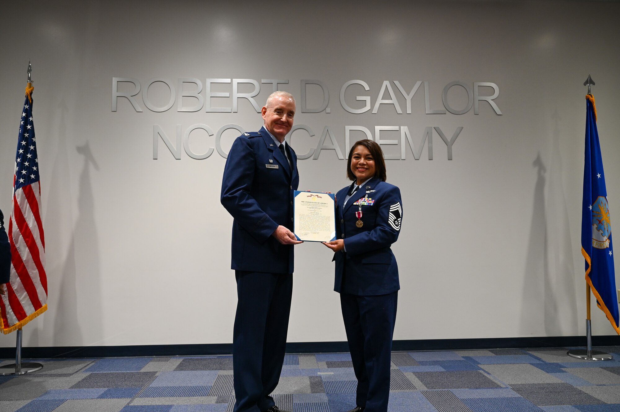 Retired Col. Michael D. Nelson, a former 433rd Medical Squadron commander, and Chief Master Sgt. Lisa Lopez, 433rd Aeromedical Evacuation Squadron senior enlisted leader, present the Meritorious Service Medal during a retirement ceremony for Lopez in Joint Base San Antonio-Lackland, Texas, Oct. 5, 2024.