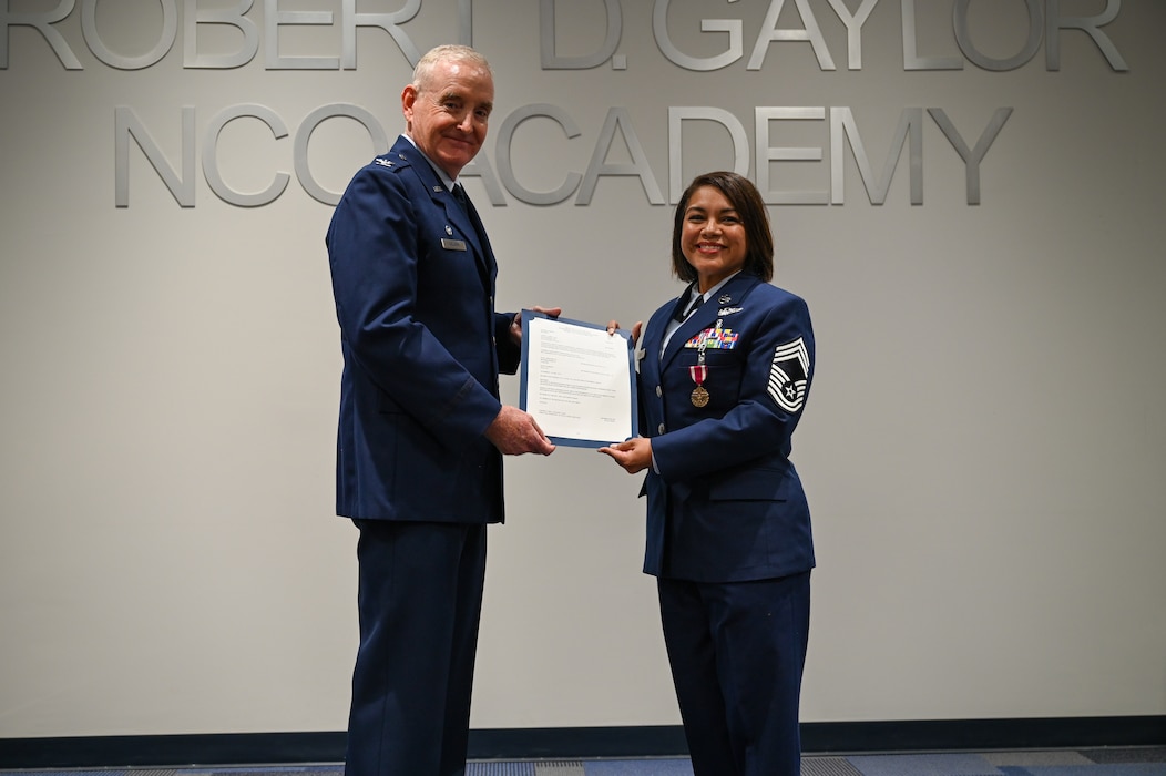 Retired Col. Michael D. Nelson, a former 433rd Medical Squadron commander, and Chief Master Sgt. Lisa Lopez, 433rd Aeromedical Evacuation Squadron senior enlisted leader, presents the Certificate of Retirement during a retirement ceremony for Lopez in Joint Base San Antonio-Lackland, Texas, Oct. 5, 2024.