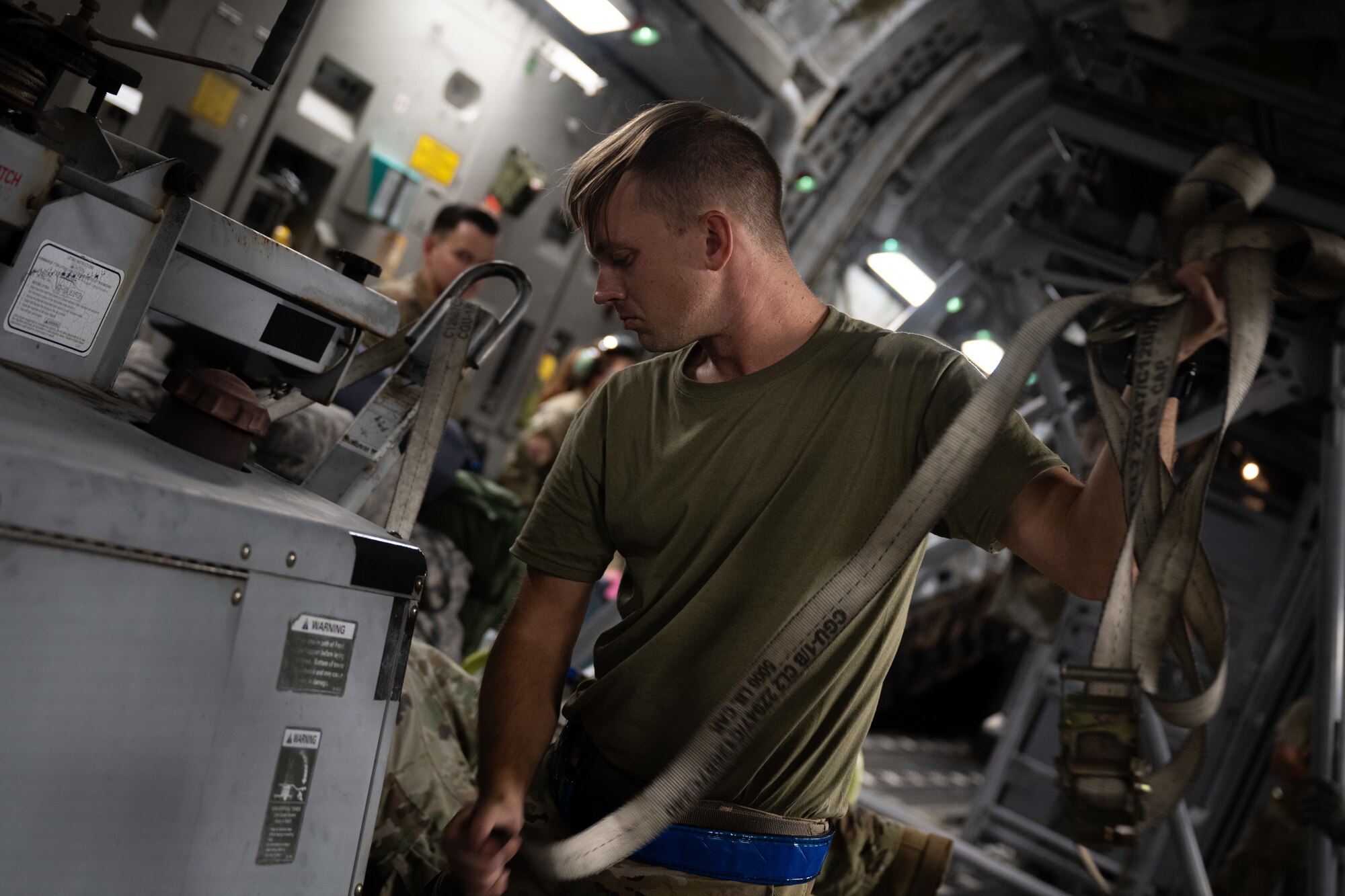 U.S. Air Force Airman pulls straps off a power cart.