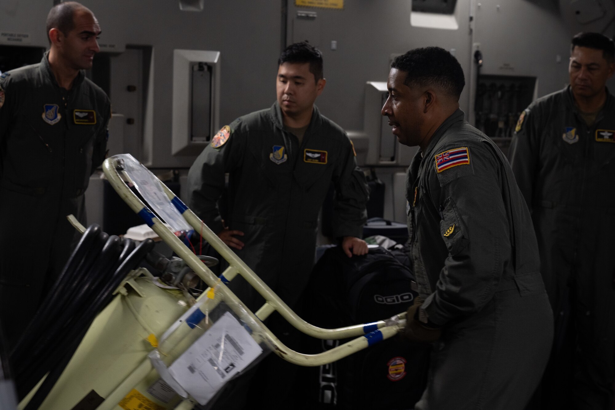 U.S. Air Force Airmen pushes an extinguisher tank off a C-17 Globemaster III aircraft.