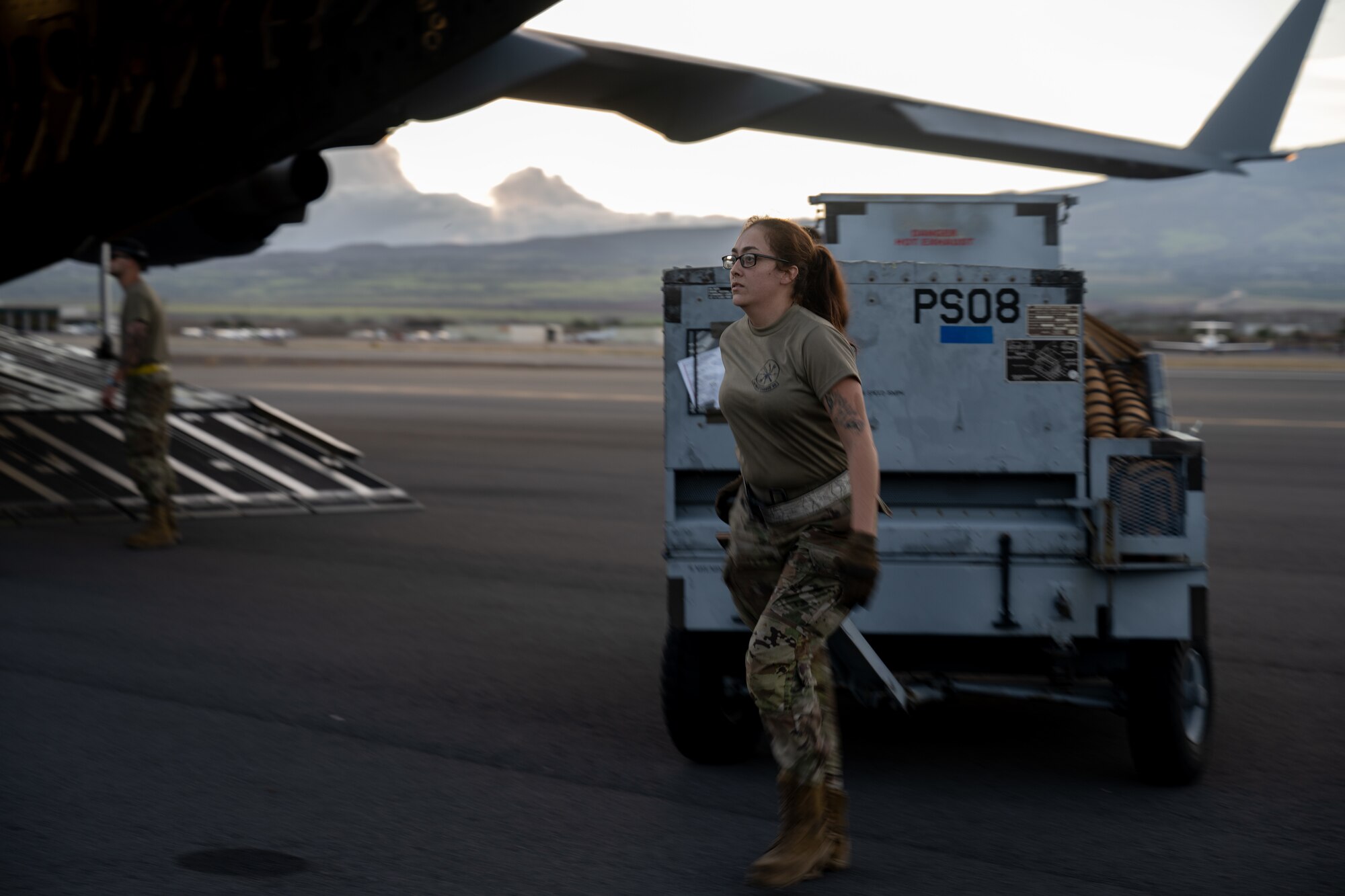 U.S. Air Force Airman pulls a power cart off a C-17 Globemaster III aircraft.
