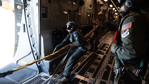 Royal Australian Air Force Corporal Felicity Hull, Number 36 Squadron loadmaster, pulls the static line parachute bags back into a C-17 Globemaster III during Joint Pacific Multinational Readiness Center 25-01 while flying over Hilo, Hawaii, Oct. 7, 2024. The Joint Pacific Multinational Readiness Center (JPMRC) is the Army’s newest Combat Training Center (CTC) and generates readiness in the environments and conditions where our forces are most likely to operate in. JPMRC 25-01 highlights our commitment to partnership and a free and open Indo-Pacific and includes training participants from across the U.S. Joint Force and multinational Allies and partners. (U.S. Air Force photo by Senior Airman Mark Sulaica)