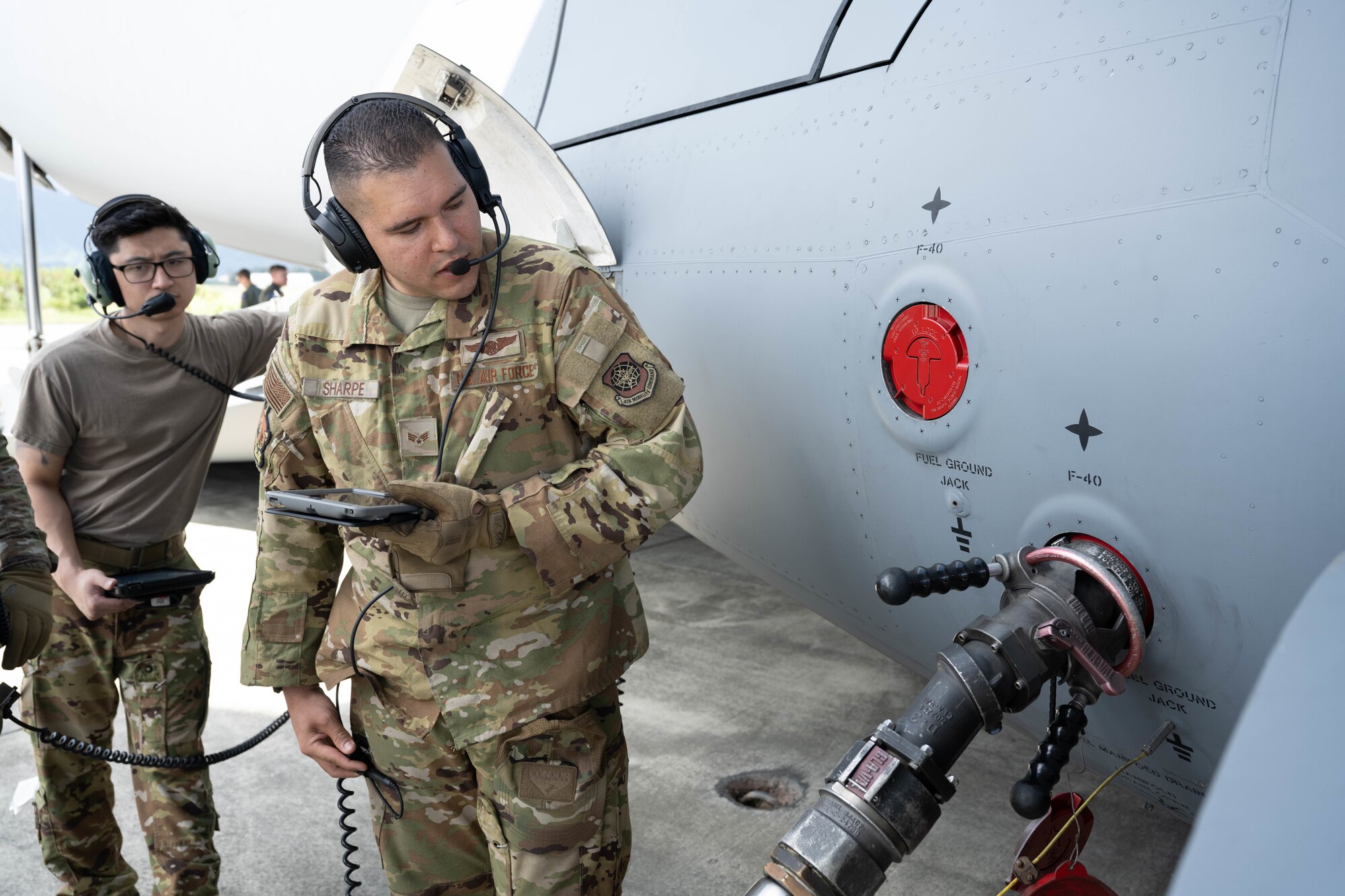 U.S. Air Force Senior Airman Nico Sharpe, 7th Airlift Squadron loadmaster, transfers fuel using the C-17 Globemaster III on the flightline of Marine Corps Base Hawaii during exercise Joint Pacific Multinational Readiness Center 25-01, Oct. 9 2024. The Joint Pacific Multinational Readiness Center (JPMRC) is the Army’s newest Combat Training Center (CTC) and generates readiness in the environments and conditions where our forces are most likely to operate in. JPMRC 25-01 includes training participants from across the U.S. Joint Force, and multinational Allies and partners. (U.S. Air Force photo by Airman 1st Class Aden Brown)