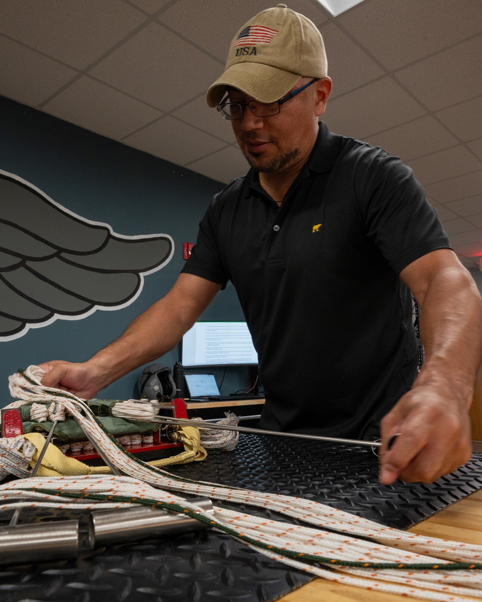 Roger Gloria, 47th Operations Support Squadron aircrew flight equipment parachute rigger, repacks the parachute rigging at Laughlin Air Force Base, Texas, Oct. 3, 2024. Packing parachute rigging is a precise process, with every line needing to be pulled and set in a certain position to ensure the parachute opens perfectly in its moment of need. (U.S. Air Force photo by Staff Sgt. Nicholas Larsen)
