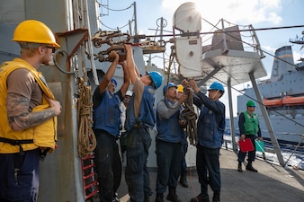 Boatswain's mates prepare the spanning wire during a replenishment aboard the USS Cole (DDG 67) in the U.S. 6th Fleet area of responsibility.