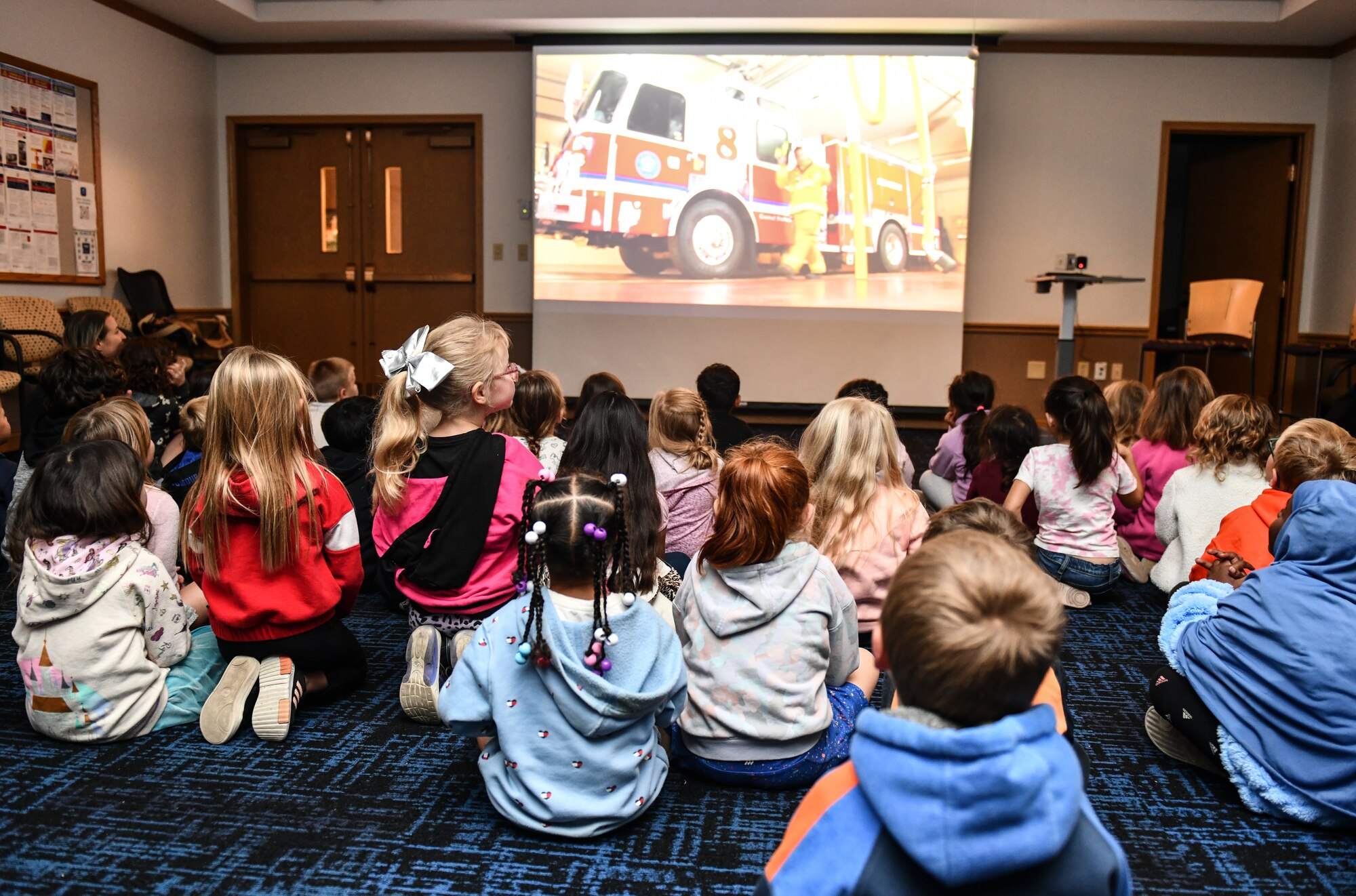Kindergarten students from Birchcrest Elementary watch a video about smoke alarms at the Offutt Air Force Base fire department during a tour for National Fire Prevention Week on Oct. 10, 2024. The theme of this year's National Fire Prevention Week was "Smoke Alarms: Make Them Work for You." (U.S. Air Force photo by Chad Watkins)