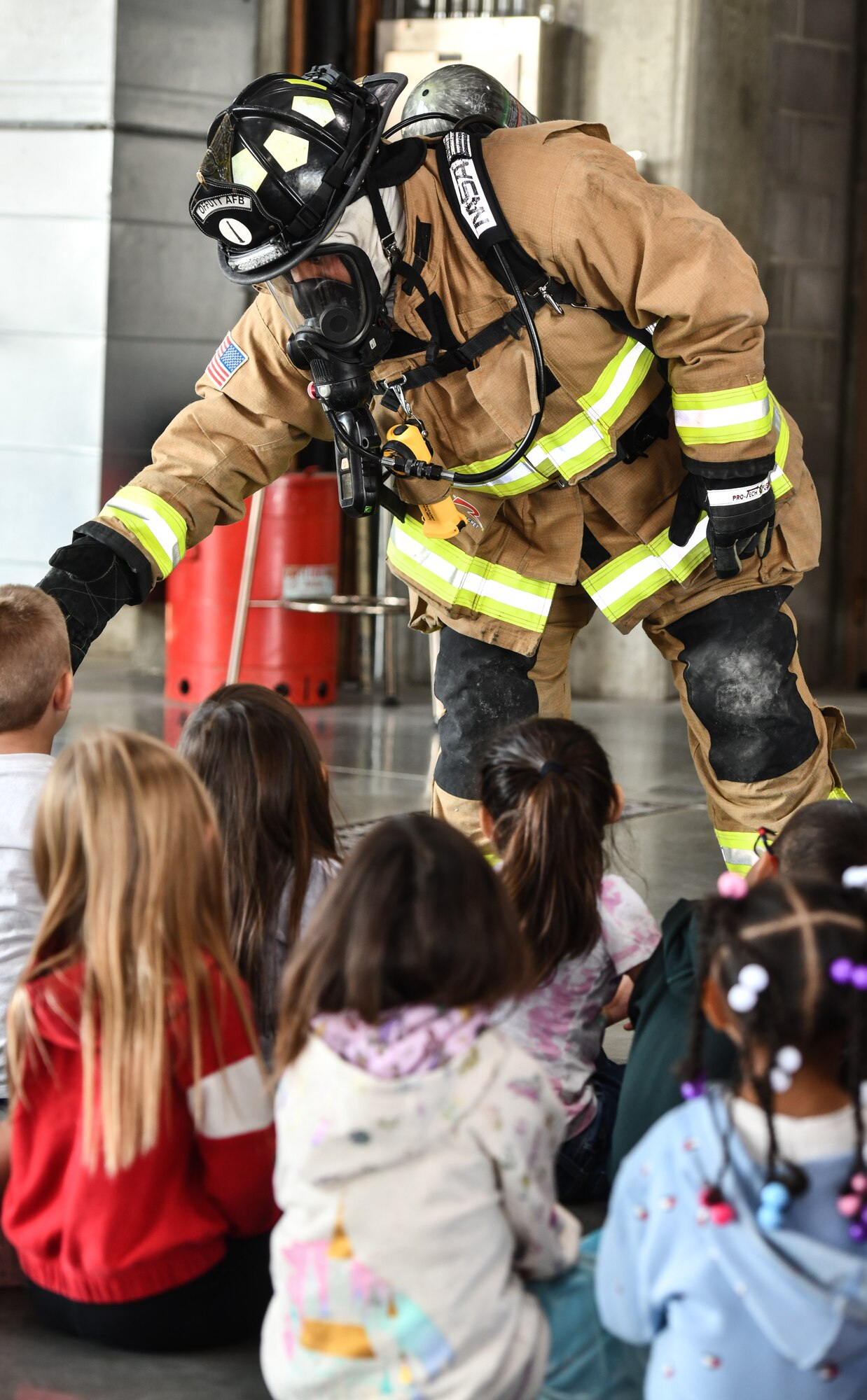Firefighter Charles Fraley, 55th Civil Engineer Squadron, interacts with Kindergarteners from Birchcrest Elementary at Offutt Air Force Base on Oct. 10, 2024. The theme of this year's National Fire Prevention Week was "Smoke Alarms: Make Them Work for You." (U.S. Air Force photo by Chad Watkins)