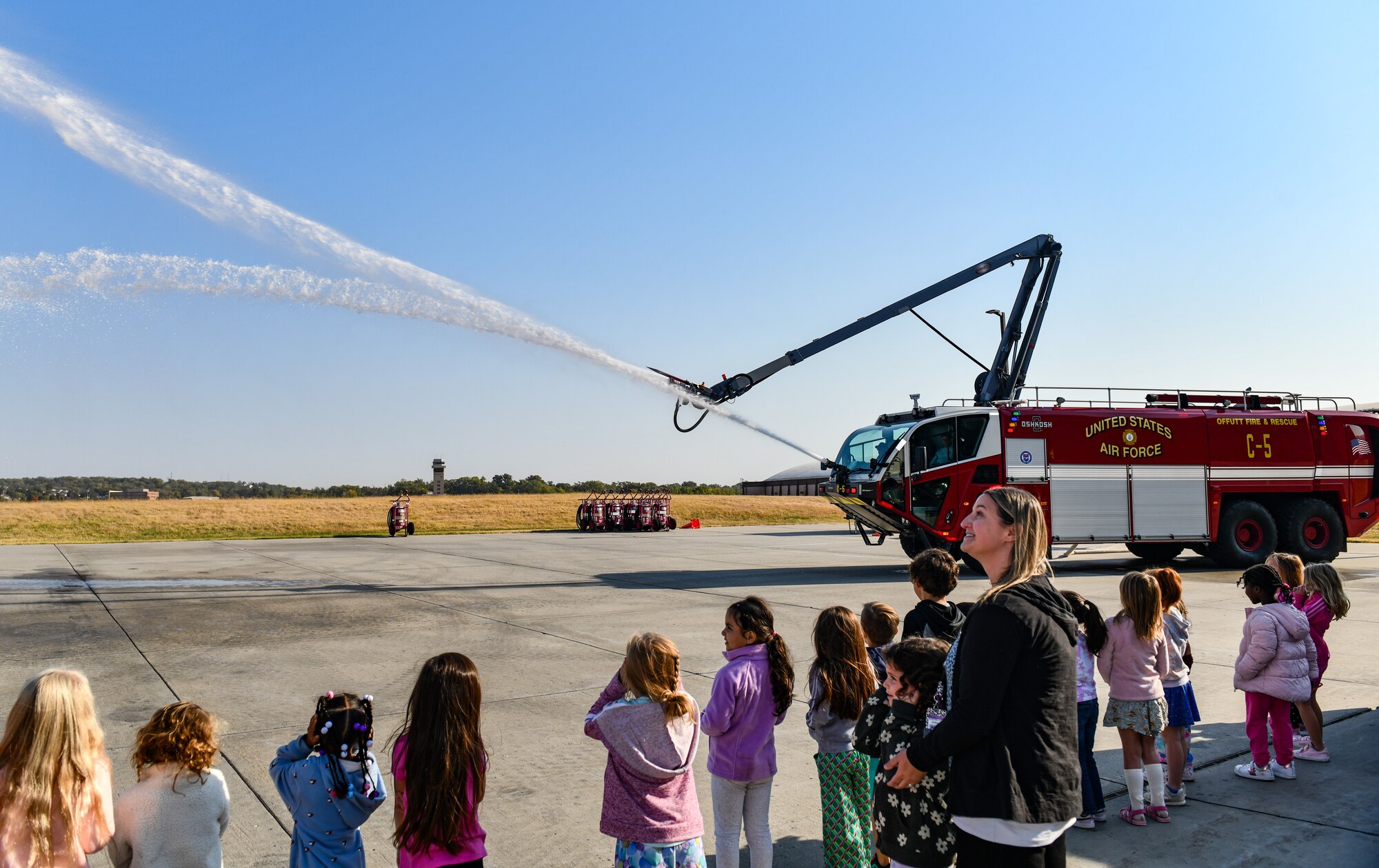 Kindergarten students from Birchcrest Elementary watch a fire engine spray water during a tour of Offutt Air Force Base's fire department during National Fire Prevention Week on Oct. 10, 2024. The theme of this year's National Fire Prevention Week was "Smoke Alarms: Make Them Work for You." (U.S. Air Force photo by Chad Watkins)