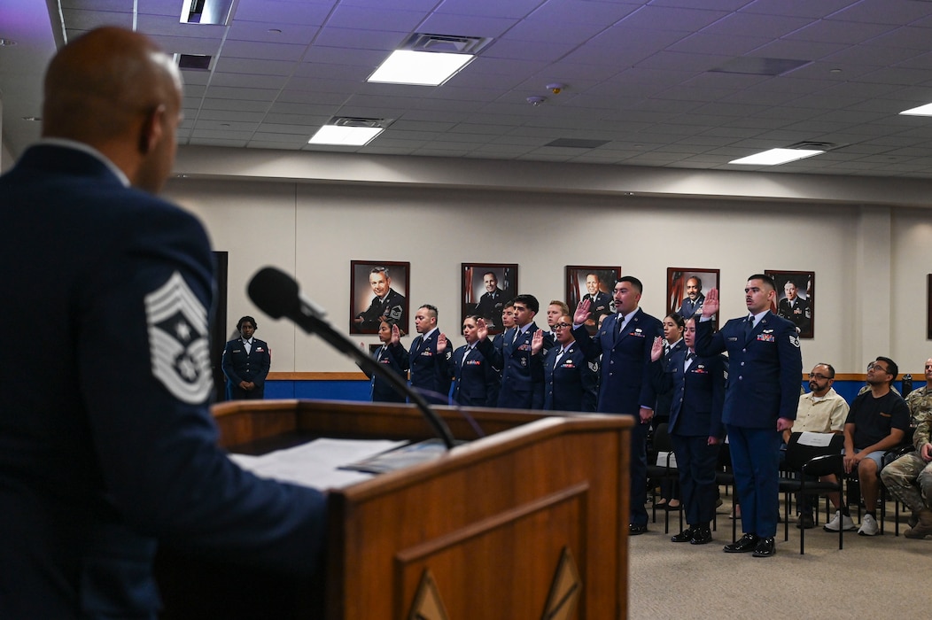 Chief Master Sgt. Jonathan J. Birk, 433rd Airlift Wing command chief, delivers the oath of induction to the newly appointed NCOs of the 433rd Airlift Wing at the Pfingston Reception Center after the NCO Induction Ceremony on Joint Base San Antonio-Lackland, Texas on October 5, 2024.