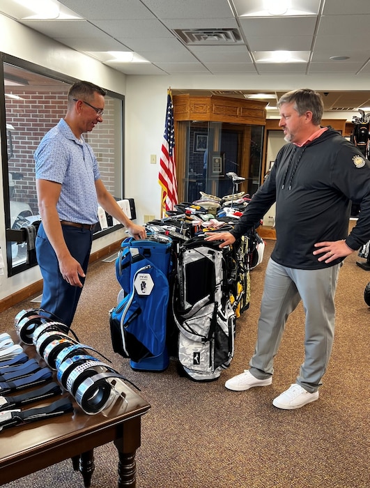 two people look at golf bags
