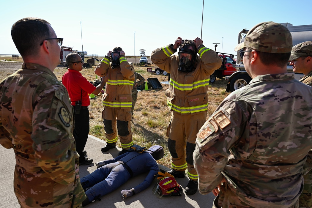 Airmen from the 97th Civil Engineer Squadron (CES) assist the 97th Mission Support Group command team in doffing personal protective equipment at Altus Air Force Base, Oklahoma, Oct. 11, 2024. The 97th CES firefighters held their annual “Eagles and Chiefs Challenge” where command teams from multiple units across the wing competed with each other in a firefighting exercise. (U.S. Air Force photo by Airman 1st Class Jonah Bliss)