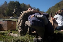 U.S. Army Sgt. Isaac Bradshaw, a combat medic with C Company, 230th Brigade Support Battalion, North Carolina Army National Guard, wraps his arms around an older couple and uses his body to block them from debris and strong winds produced by the rotorwash of a landing CH-47 Chinook helicopter in Burnsville, North Carolina, Oct. 10, 2024. The Chinook crew brought generators, fuel and other supplies to the remote area after floodwaters washed away the main road after Hurricane Helene.
