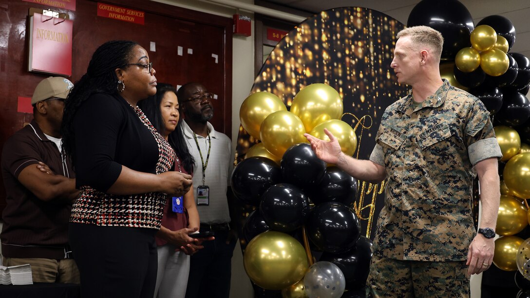 Jackie Jarrett, deputy comptroller, Blount Island Command, listens to U.S. Marine Corps Col. Luke Watson, commanding officer, during an employee appreciation break Sept. 30, 2024, at Marine Corps Support Facility Blount Island in Florida.