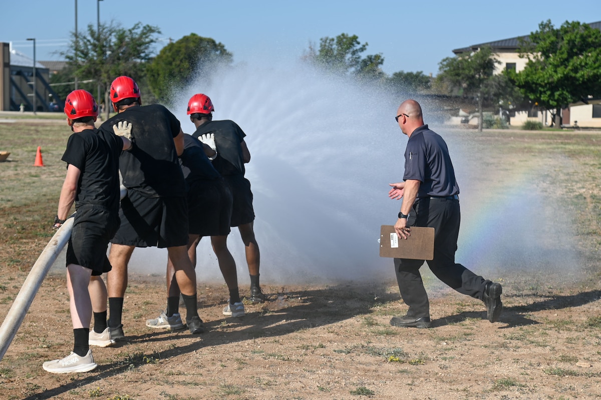 U.S. Army soldiers assigned to the 344th Intelligence Battalion sprayed a firehose at a target during the annual Fire Muster, a timed challenge for base personnel to complete a series of fire-related activities at Goodfellow Air Force Base, Texas, Oct. 11, 2024. The Fire Muster is a timed challenge for base personnel to complete a series of fire-related activities, such as hose handling, equipment retrieval, and simulated rescue tasks. (U.S. Air Force photo by Airman 1st Class James Salellas)