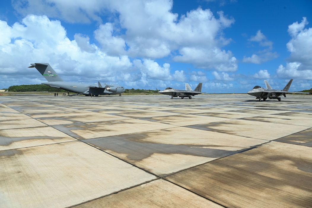 A U.S. Air Force C-17 Globemaster III from Joint Base Lewis-McChord and F-22 Raptors from Hickam Air Force Base sit on the flight line at Marine Corps Base Hawaii during Exercise Rainier War 25A, Oct. 9, 2024.