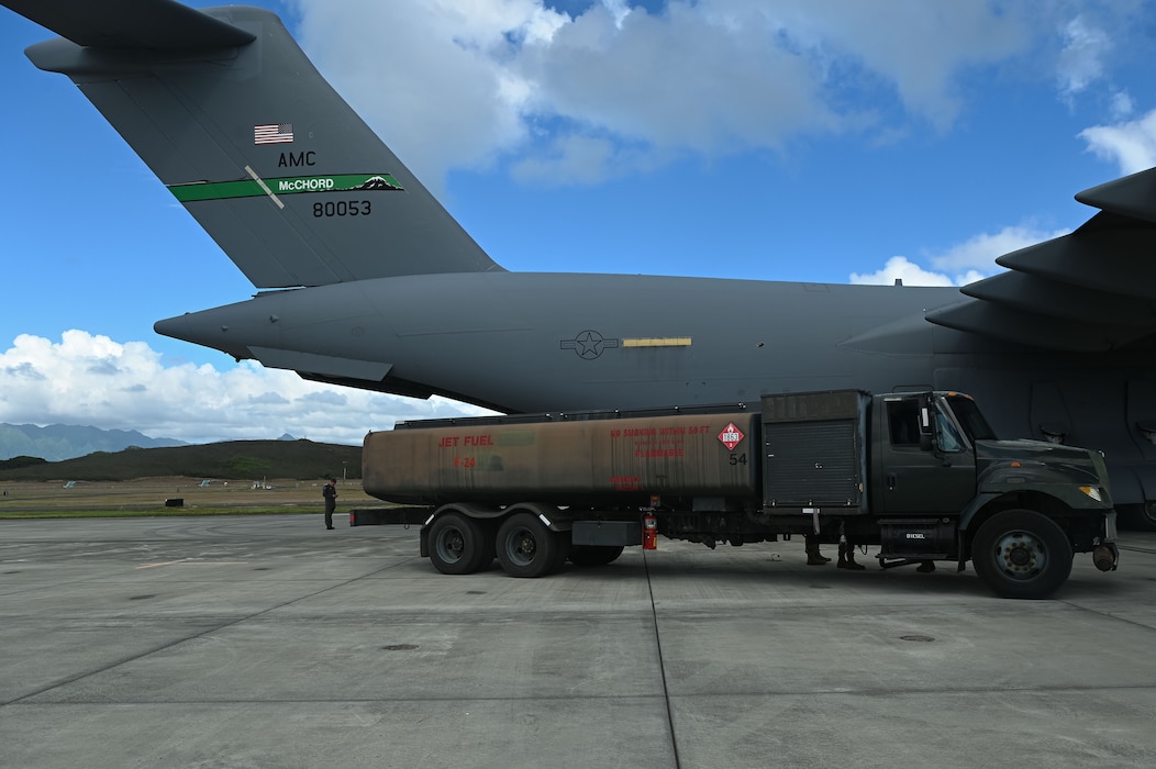 A 62d Logistics Readiness Squadron Petroleum, Oils, and Lubricants (POL) truck sits positioned next to a C-17 Globemaster III during Exercise Rainier War 25A at Marine Corps Base Hawaii, Oct. 9, 2024.