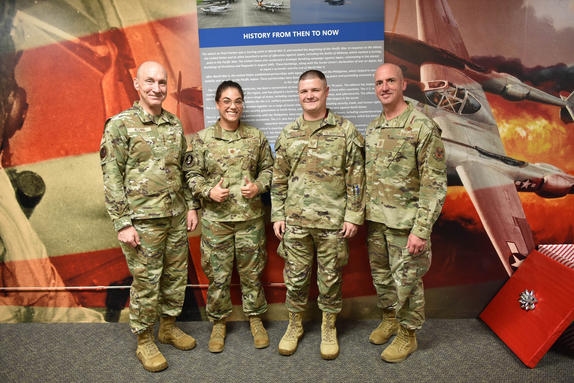 Air Force Chief of Staff Gen. David Allvin and Chief Master Sgt. of the Air Force David Flosi stand together for a group photo with two Airmen.