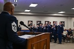 Chief Master Sgt. Jonathan J. Birk, 433rd Airlift Wing command chief, delivers the oath of induction to the newly appointed NCOs of the 433rd Airlift Wing at the Pfingston Reception Center after the NCO Induction Ceremony on Joint Base San Antonio-Lackland, Texas on October 5, 2024.