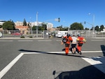 Two Coast Guardsmen escort a man to an awaiting ambulance.