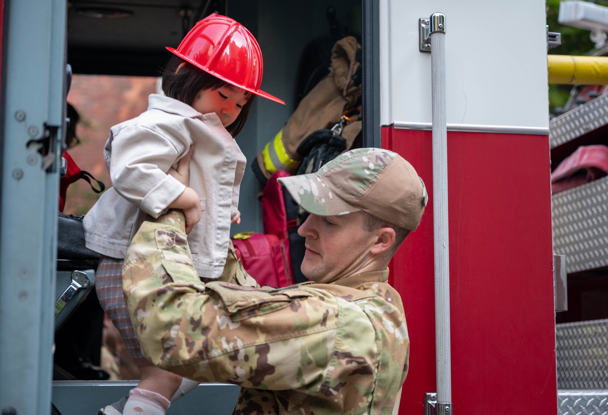 U.S. Air Force Staff Sgt. Jeremiah Baird, 51st Civil Engineer Squadron lead firefighter, assists a Republic of Korea student off a fire truck as part of Fire Prevention Week at Osan Air Base, Republic of Korea, Oct. 8, 2024. Firefighters assigned to the 51st Civil Engineer Squadron were delivering public education aimed at reducing fire related accidents. (U.S. Air Force photo by Staff Sgt. Christopher Tam)