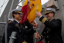 Cmdr. Scott Burrill, the commanding officer of the Arleigh-Burke class guided-missile destroyer USS Oscar Austin (DDG 79), raises a Spanish flag with Spanish Armada Capt. Ernesto Guesos, Commander, 41st Frigate Squadron, during the ship's homeport shift to Naval Station (NAVSTA) Rota, Spain, from NAVSTA Norfolk, Va., Oct. 15, 2024.