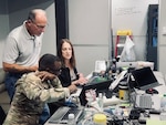 Three people are working together on a task force in a mobile vehicle.