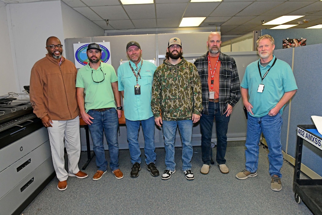 A group of people standing and posing at the camera