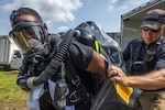 U.S. Army Maj. Travis Jacob, right, physician’s assistant, 24th Weapons of Mass Destruction-Civil Support Team, New York National Guard, assists Staff Sgt. Christopher R. Wall, survey team member, 21st WMD-CST, New Jersey National Guard, into his Level A Protective Suit during an Army North-mandated training proficiency evaluation at the New Jersey Air Victory Museum on Lumberton, New Jersey, Aug. 6, 2024. The 21st WMD-CST identifies chemical, biological, radiological, and nuclear substances; assess and advises civil authorities on response measures to man-made or natural disasters.